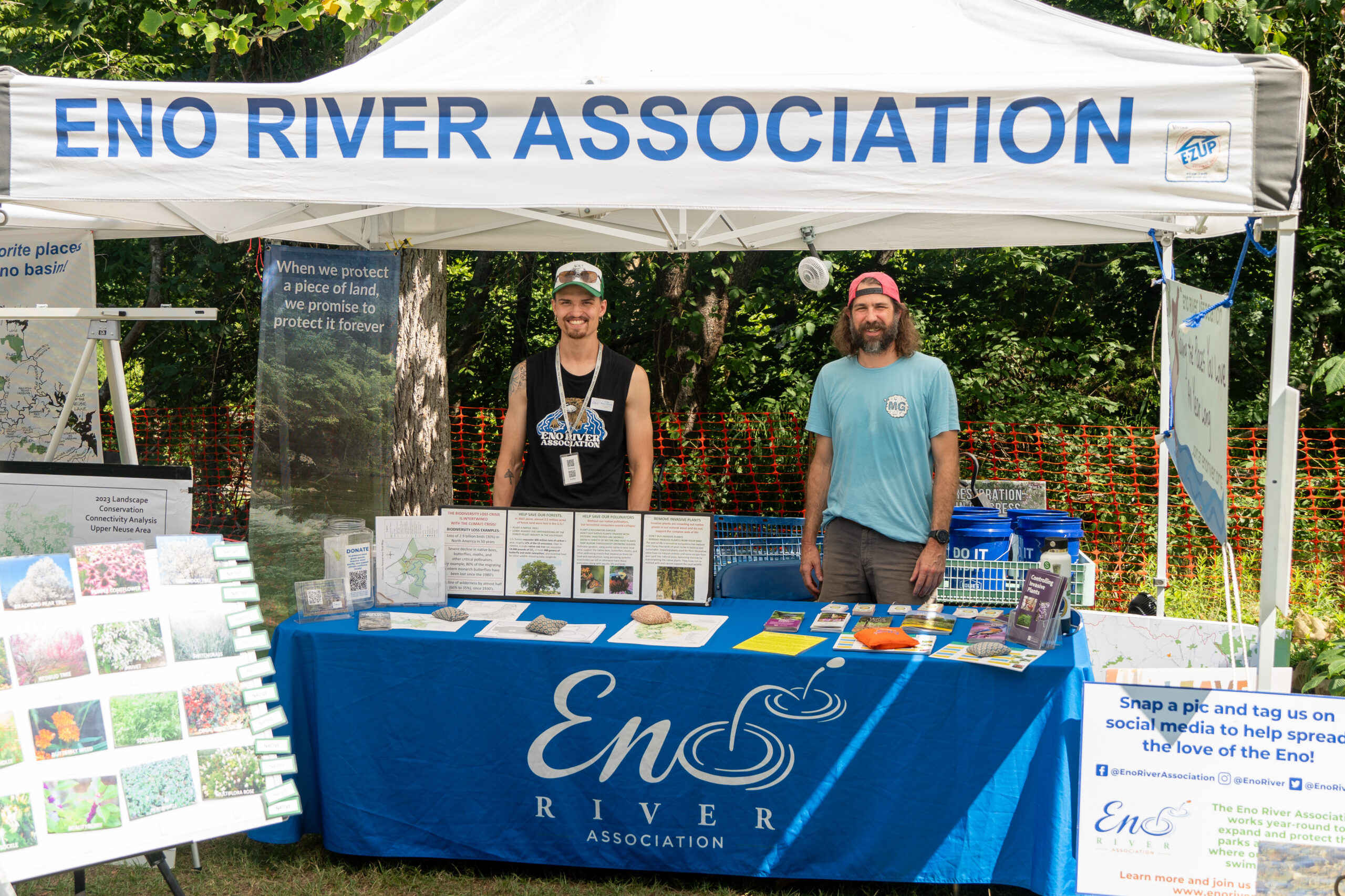 Eno River Association Staff Smiling at a table with information and resources about the eno river.