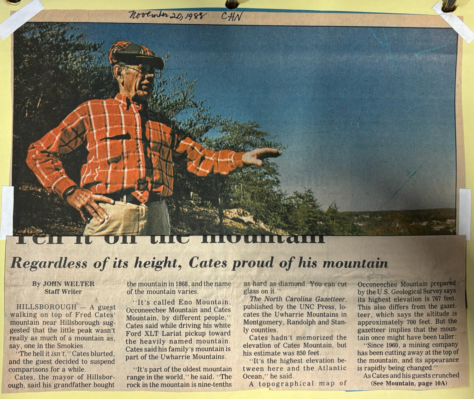 An article depicting a visitor to Occoneechee Mountain holding out his hand overlooking the land, expressing that "Regardless of its height, Cates [is] proud of his mountain" suspending comparisons to larger mountains for the sake of appreciating the Occoneechee mountain for the local community of Hillsborough.