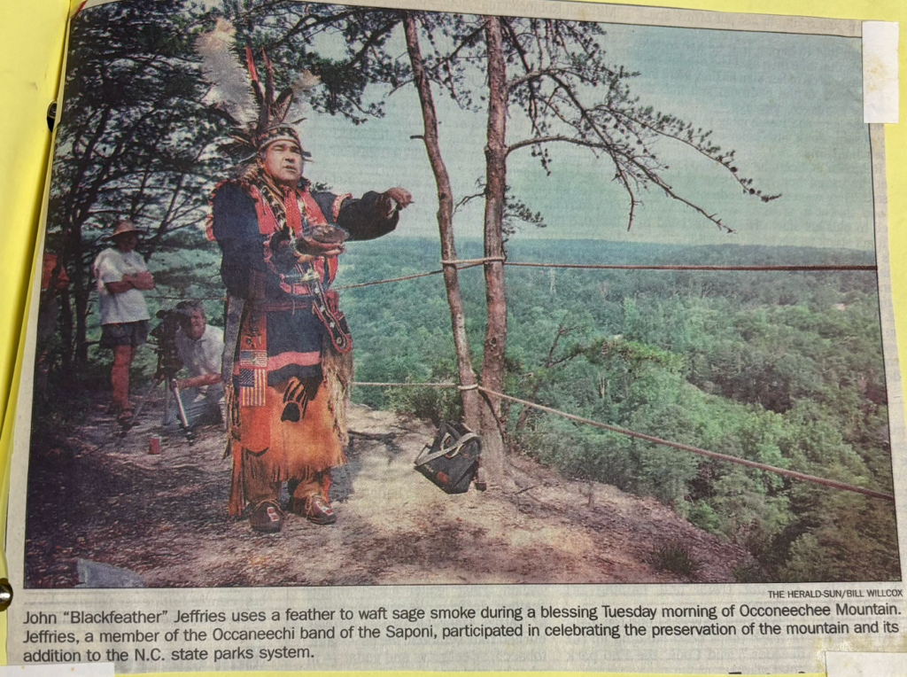John "Blackfeather" Jeffries uses a feather to waft sage smoke during a blessing Tuesday morning of Occoneechee Mountain. Jeffries, a member of the Occaneechi Band of the Saponi Nation, participated in celebrating the preservation of the mountain and its addition to the N.C. state parks system.