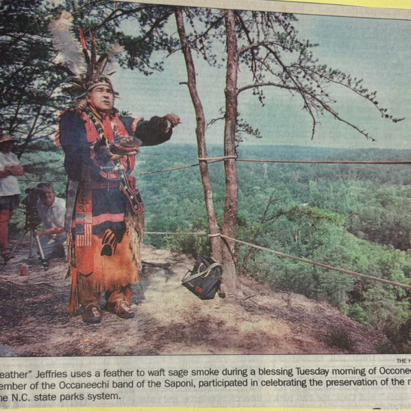 John "Blackfeather" Jeffries uses a feather to waft sage smoke during a blessing Tuesday morning of Occoneechee Mountain. Jeffries, a member of the Occaneechi Band of the Saponi Nation, participated in celebrating the preservation of the mountain and its addition to the N.C. state parks system.